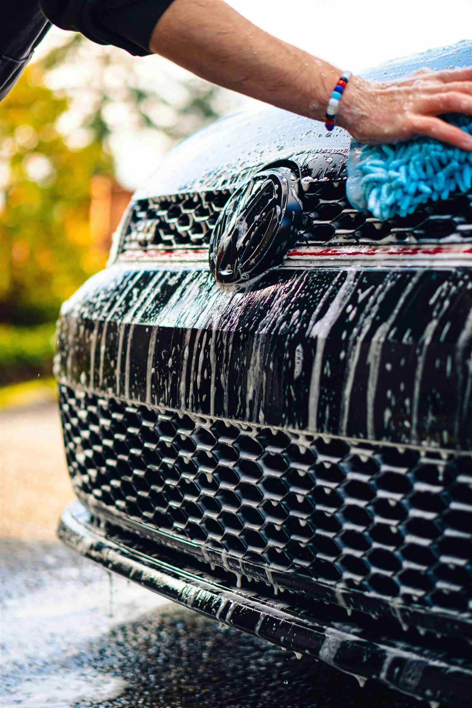A freshly washed dark car, photographed from the front